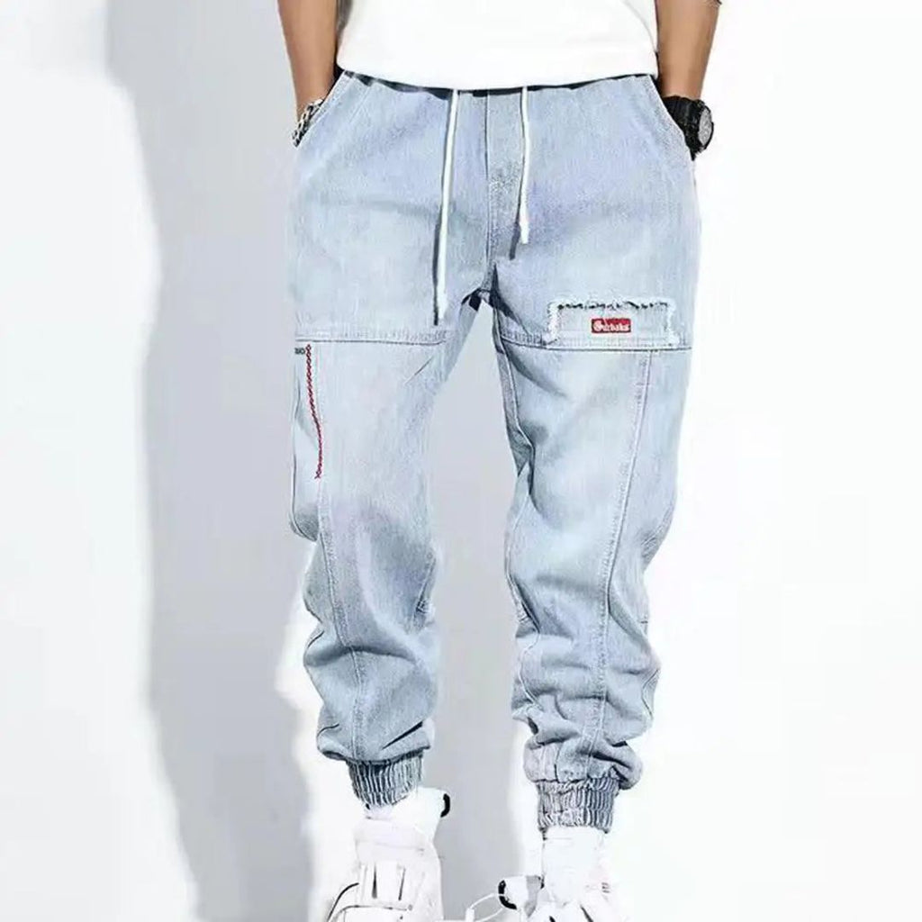 Men's denim jogger trousers in light blue, worn