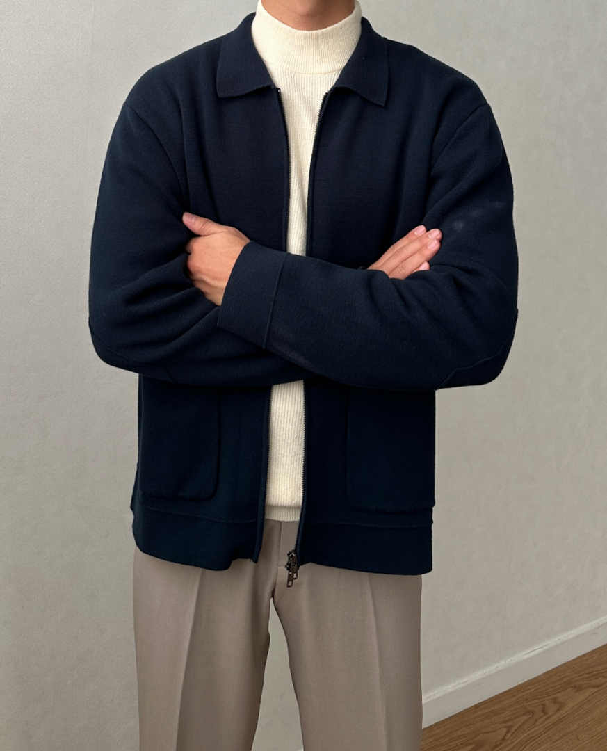 Man wearing the knit zip jacket in navy – arms crossed