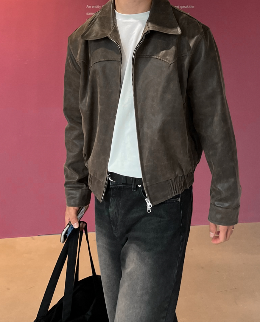 Man wearing the leather-look zip jacket in brown – with a bag