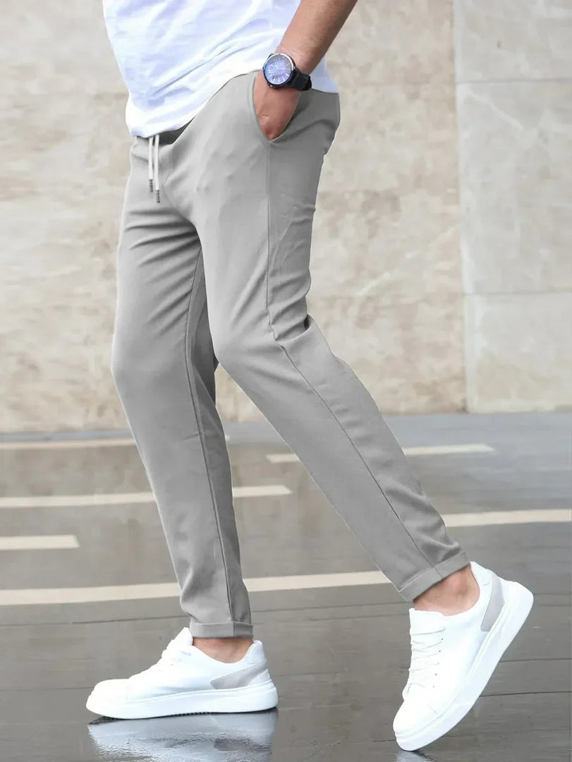 Man wearing the slim fit stretch trousers in grey – walking