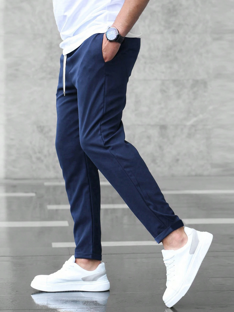 Man wearing the slim fit stretch trousers in navy – walking