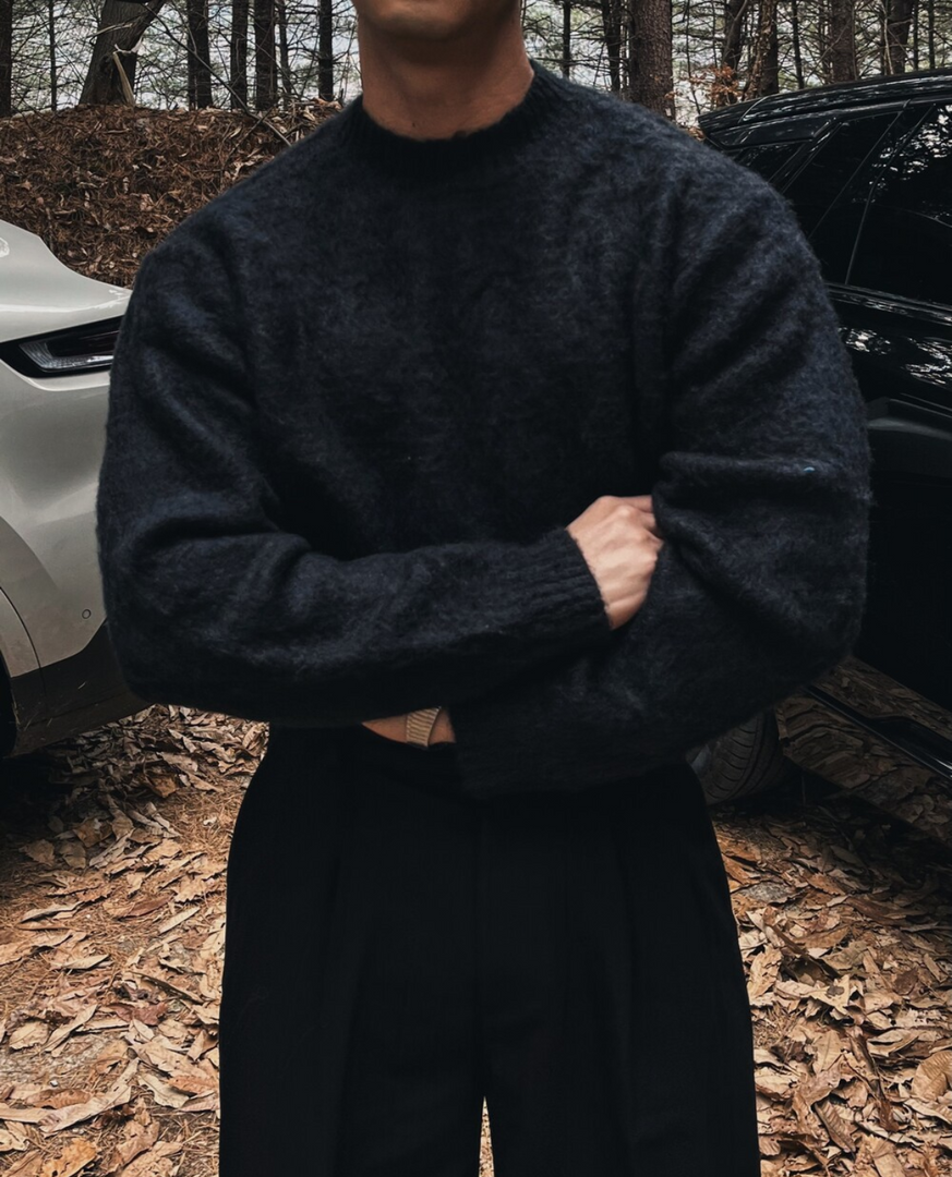 Man wearing the soft knit crew neck sweater in black – arms crossed