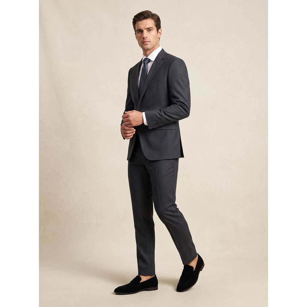 Men's suede-look penny loafers in black, worn with a suit