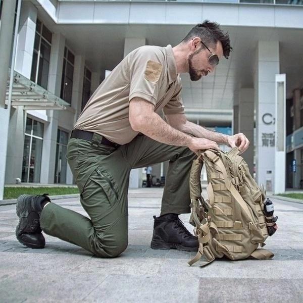 Man wearing the water-repellent cargo trousers in green – kneeling