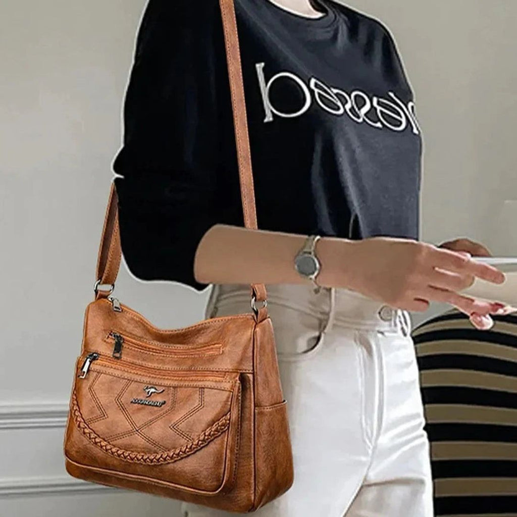 Women's leather look crossbody bag with zip pockets in tan, worn crossbody