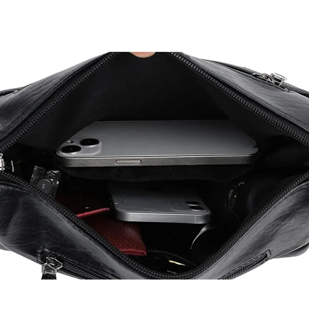 Women's leather look crossbody bag with zip pockets in black, inside view