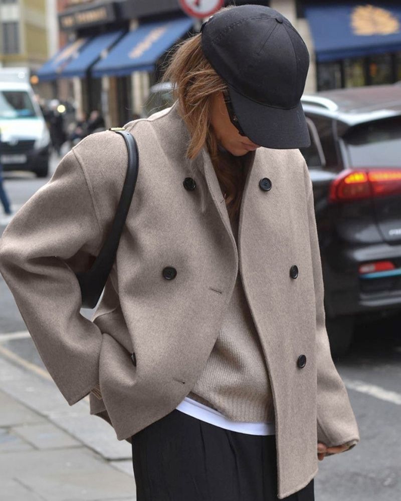 Women's oversized short double-breasted coat in taupe – worn with a cap