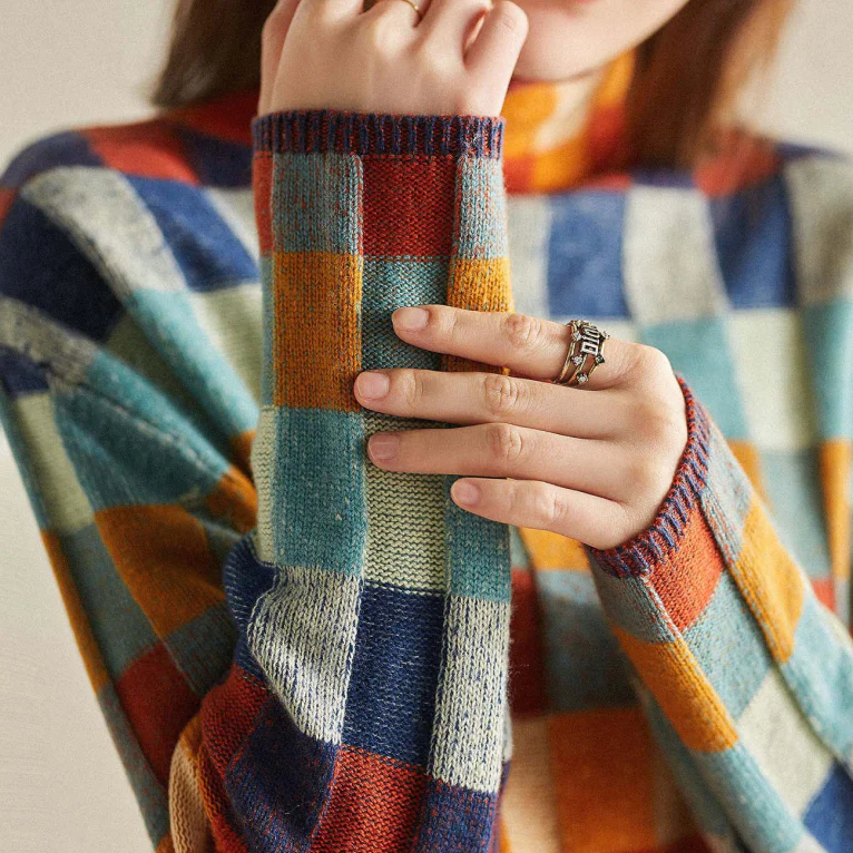 Close-up of the check sleeve on the women's knit sweater