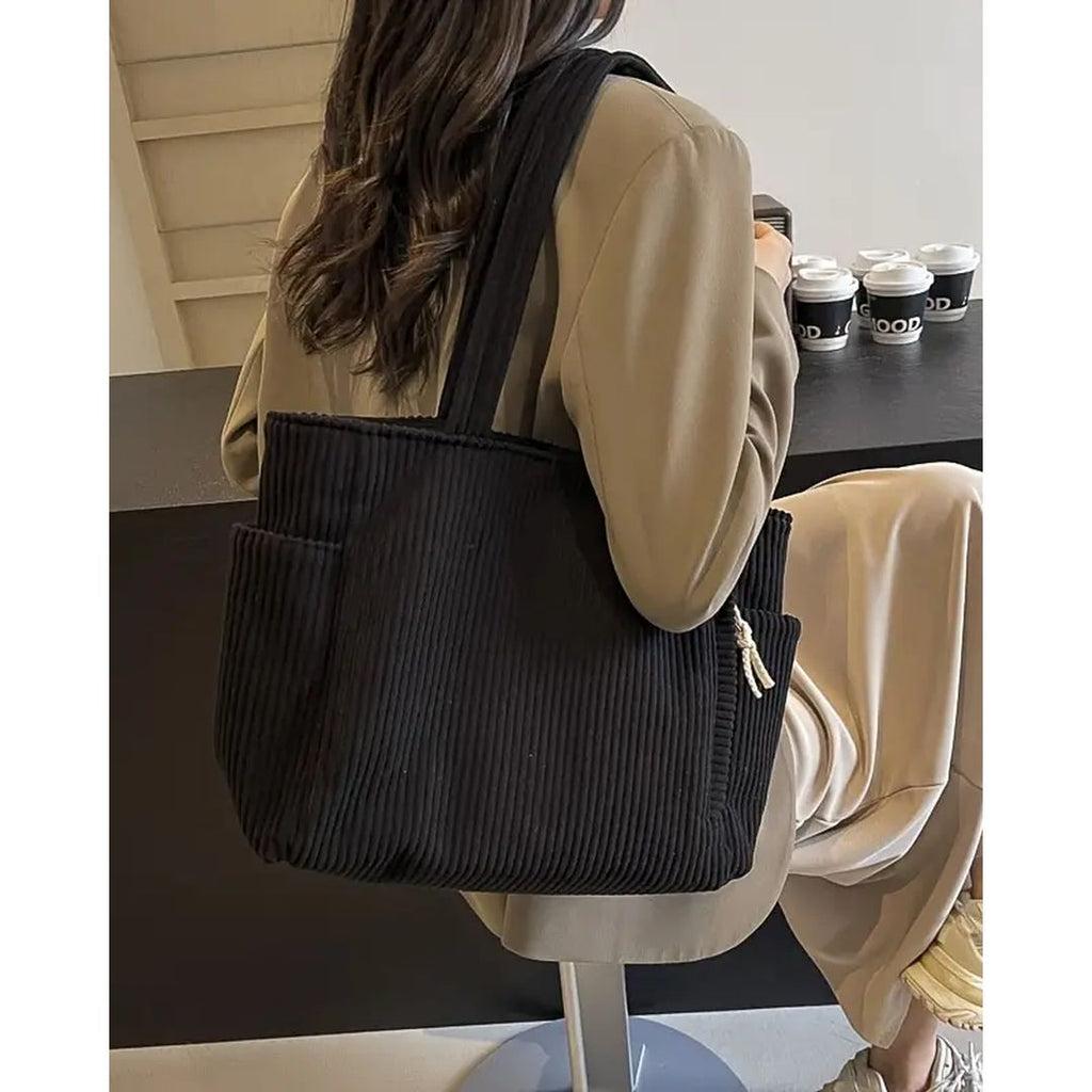 Women's ribbed tote bag with side pockets in black, on the shoulder