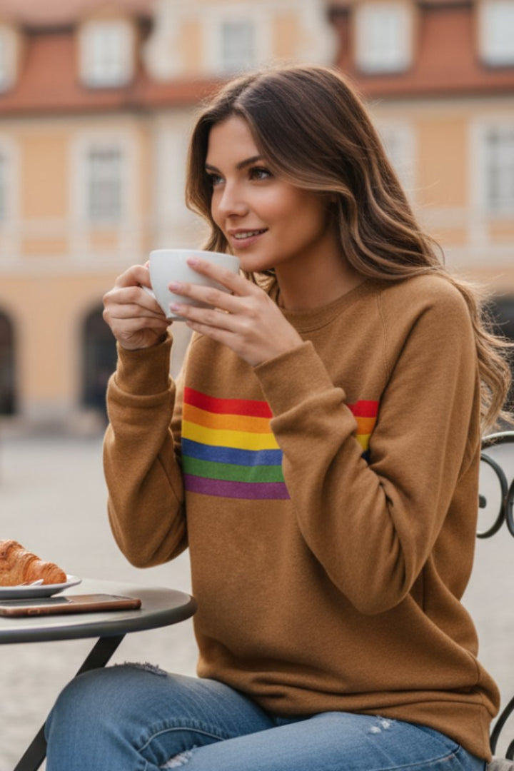 Women's rainbow stripe sweater in yellow – in a café