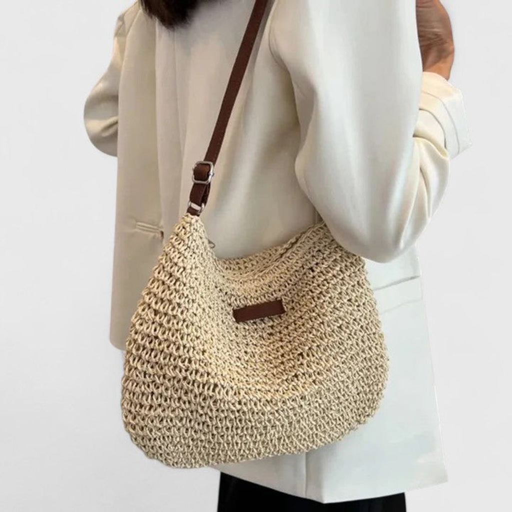 Women's woven half moon shoulder bag in natural, worn on the shoulder
