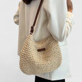 Women's woven half moon shoulder bag in natural, worn on the shoulder
